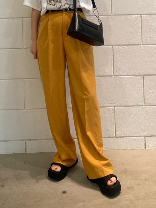 オレンジ系のその他パンツ、ブラック系のハンドバッグ、ホワイト系のTシャツ/カットソーを着用したレディースの春コーディネートの7枚目の写真