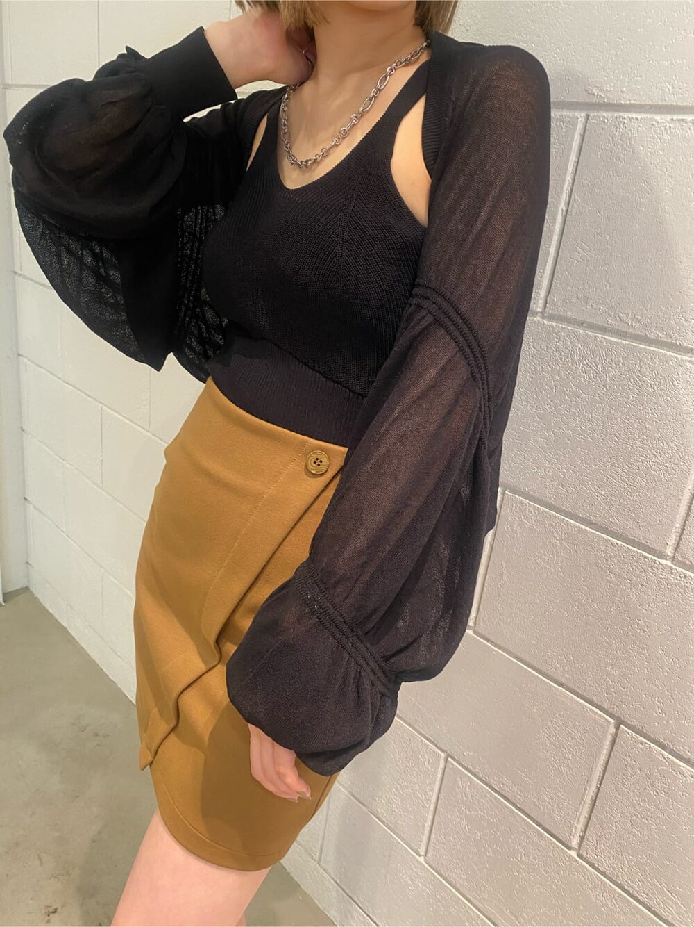 イエロー系のスカート、ブラック系のサンダル、ブラック系のカーディガン/ボレロを着用したレディースの夏コーディネートの5枚目の写真