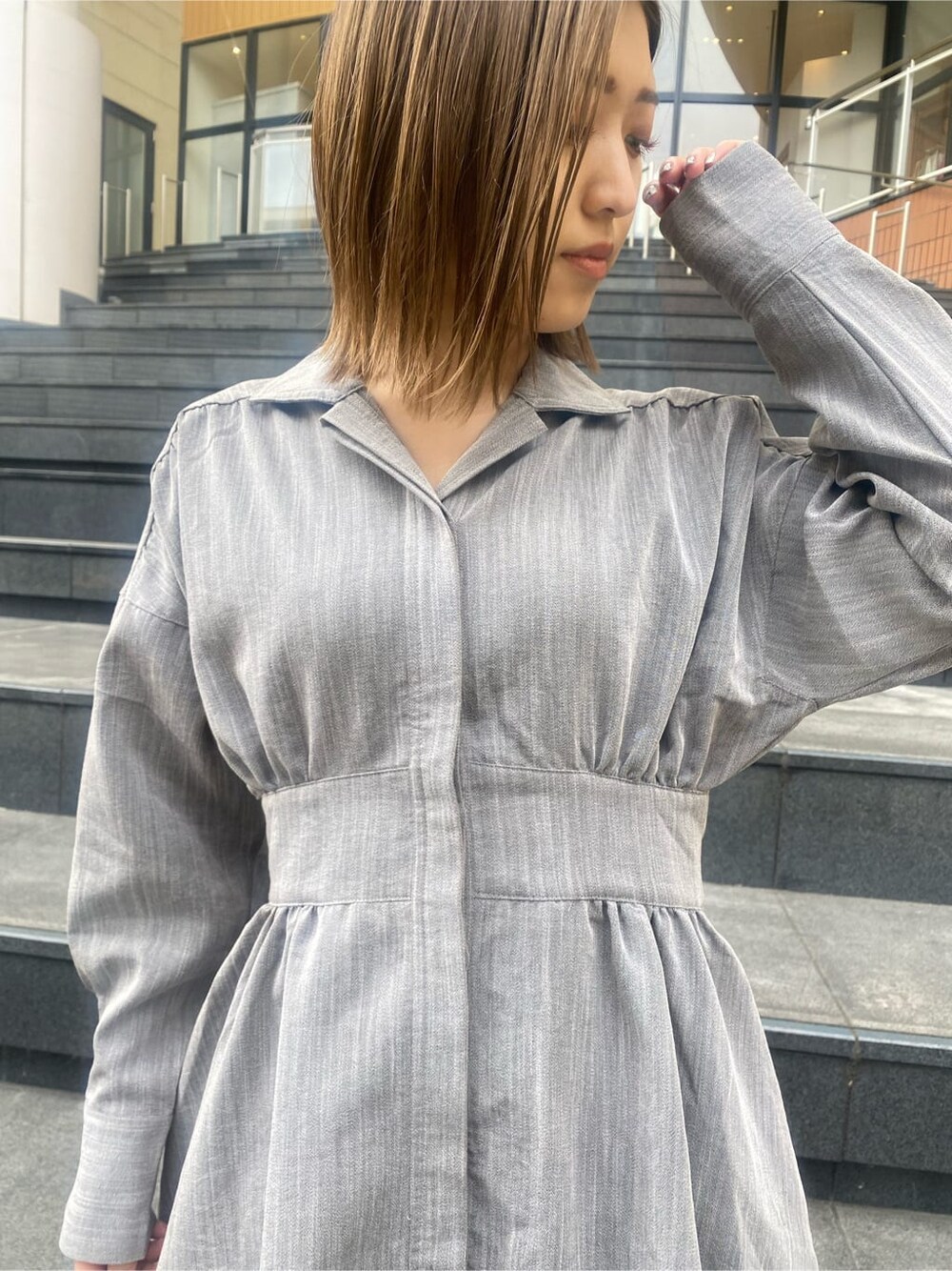 グレー系のシャツワンピース、ブラック系のブーツを着用したレディースの冬コーディネートの6枚目の写真