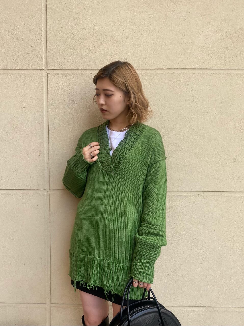 ブラック系のスカート、ブラック系のブーツ、ホワイト系のTシャツ/カットソーを着用したレディースの秋コーディネートの7枚目の写真