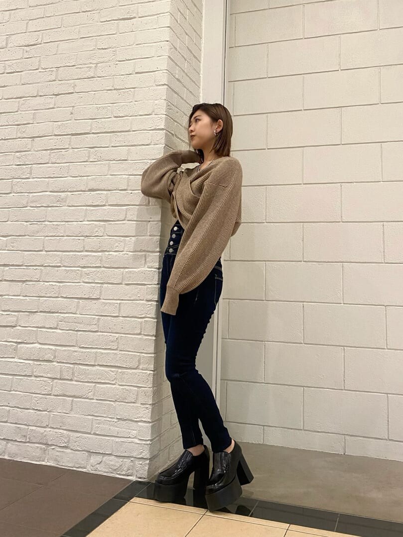 ブルー系のデニムパンツ、ブラック系のローファー、ベージュ系のニット/セーターを着用したレディースの冬コーディネートの2枚目の写真