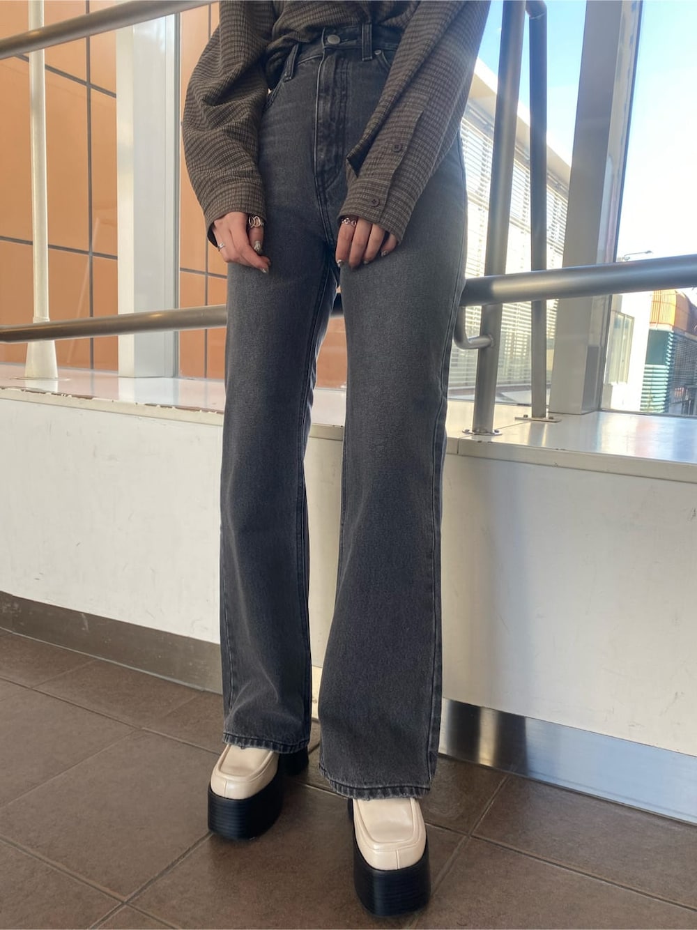 ホワイト系のローファー、グレー系のデニムパンツ、ブラウン系のシャツ/ブラウスを着用したレディースの冬コーディネートの6枚目の写真