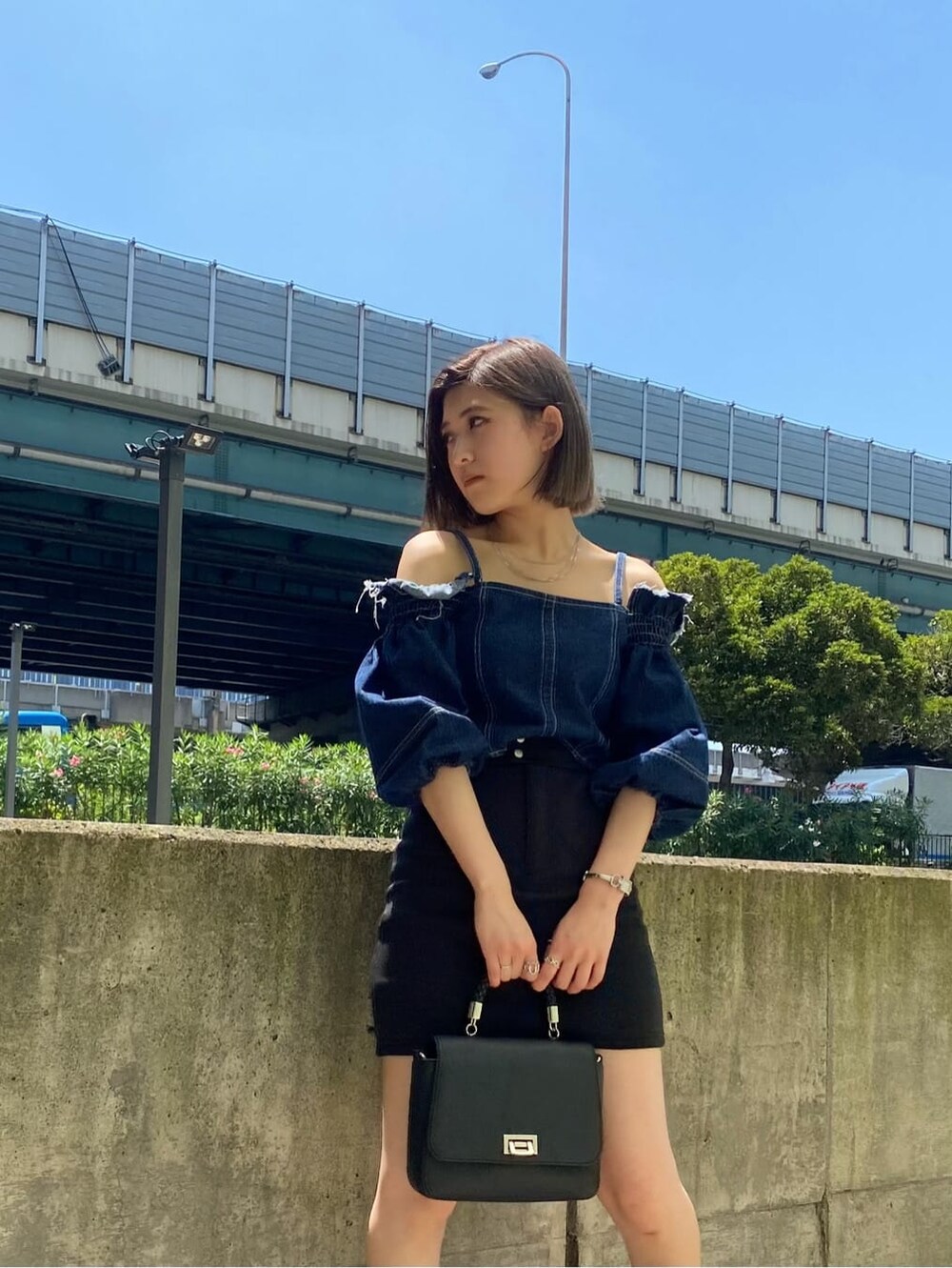 ブラック系のスカート、ブラック系のサンダル、ブルー系のシャツ/ブラウスを着用したレディースの夏コーディネートの2枚目の写真