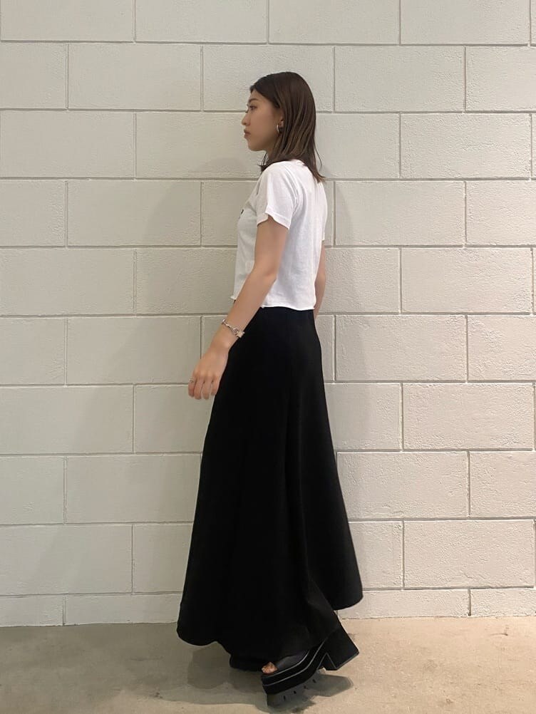 ブラック系のスカート、ブラック系のサンダル、ホワイト系のTシャツ/カットソーを着用したレディースの夏コーディネートの2枚目の写真