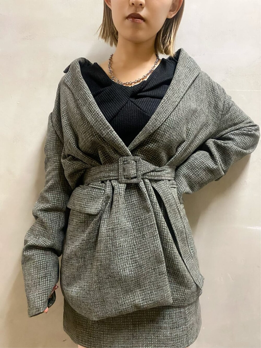 ベージュ系のテーラードジャケット、ベージュ系のスカート、ブラック系のブーツを着用したレディースの秋コーディネートの7枚目の写真