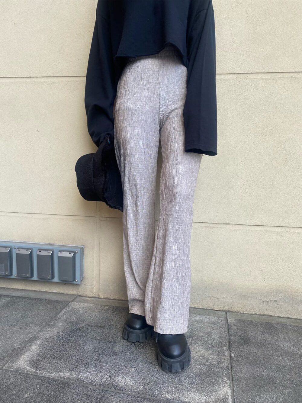 グレー系のその他パンツ、ブラック系のサンダル、ホワイト系のTシャツ/カットソーを着用したレディースの春コーディネートの7枚目の写真