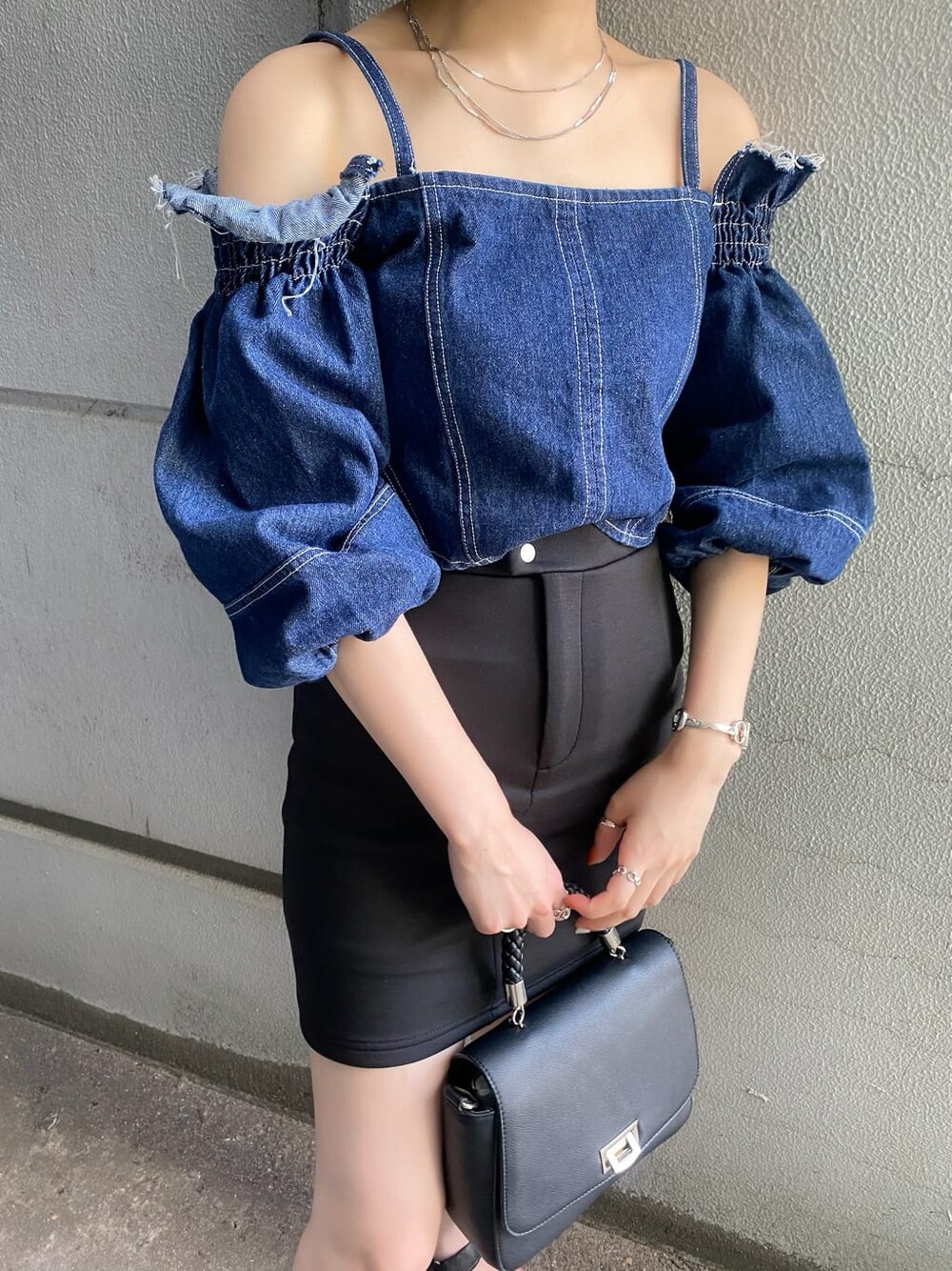 ブラック系のスカート、ブラック系のサンダル、ブルー系のシャツ/ブラウスを着用したレディースの夏コーディネートの3枚目の写真