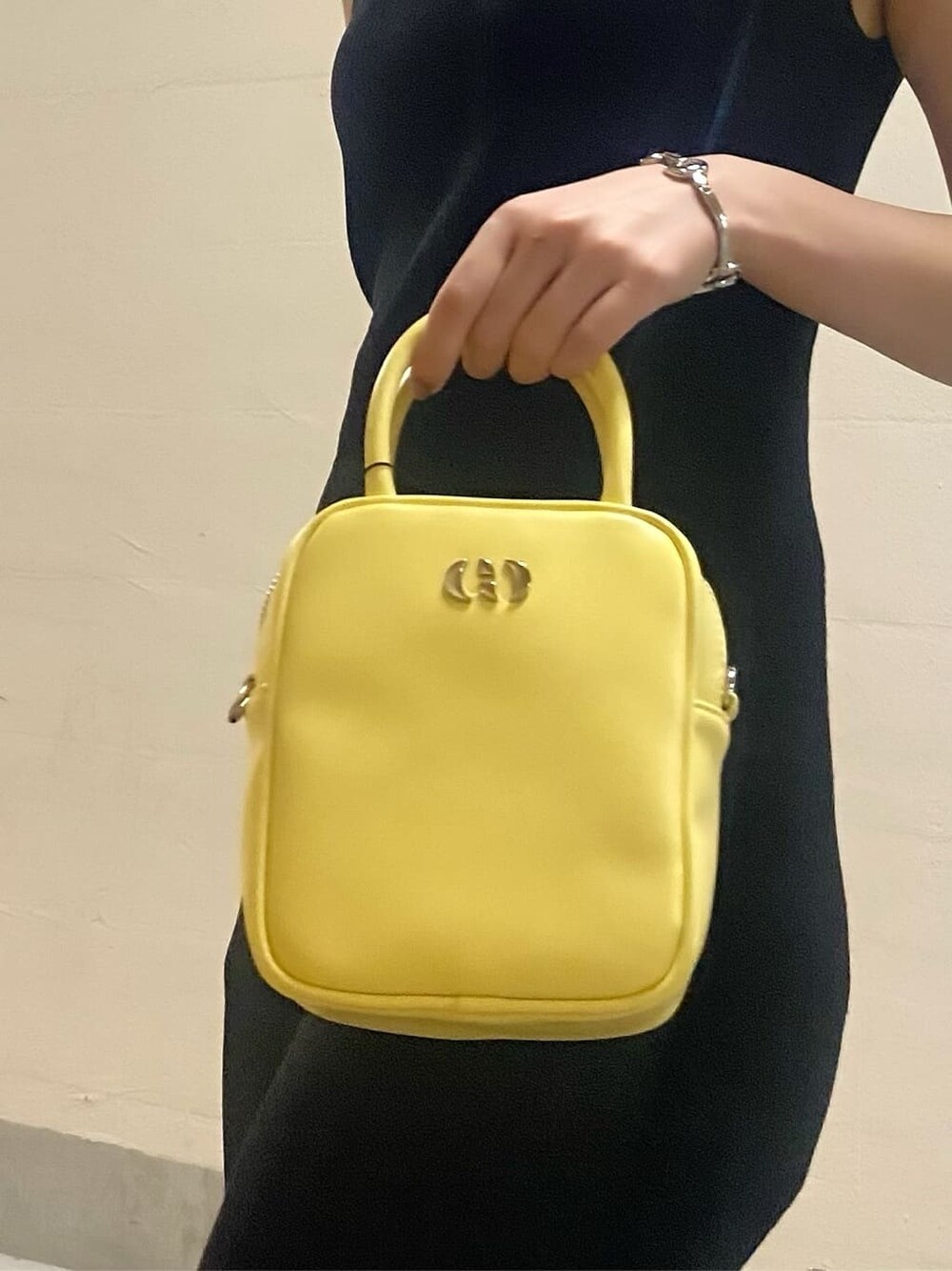 ホワイト系のブーツ、イエロー系のショルダーバッグ、ブラック系のワンピースを着用したレディースの春コーディネートの8枚目の写真