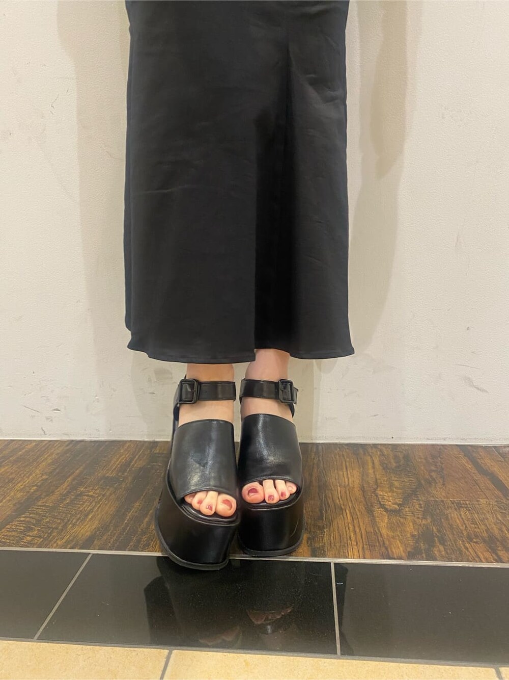 ブラック系のスカート、ブラック系のサンダル、ブルー系のTシャツ/カットソーを着用したレディースの春コーディネートの10枚目の写真