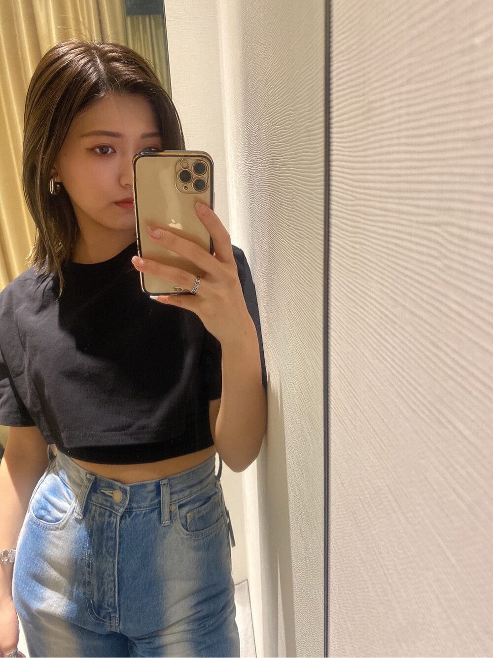 ブラック系のサンダル、ブラック系のTシャツ/カットソー、ブルー系のデニムパンツを着用したレディースの春コーディネートの3枚目の写真
