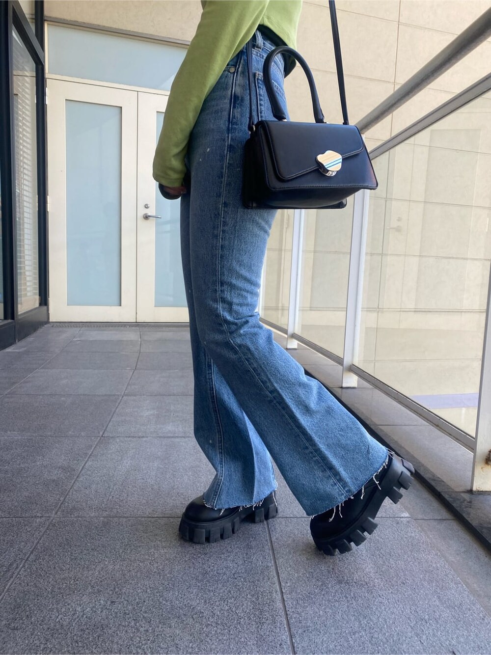 ブラック系のブーツ、ブルー系のデニムパンツ、イエロー系のTシャツ/カットソーを着用したレディースの冬コーディネートの9枚目の写真