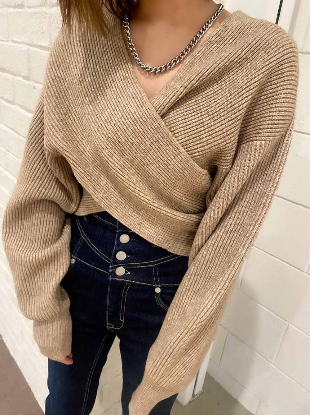 ブルー系のデニムパンツ、ブラック系のローファー、ベージュ系のニット/セーターを着用したレディースの冬コーディネートの5枚目の写真