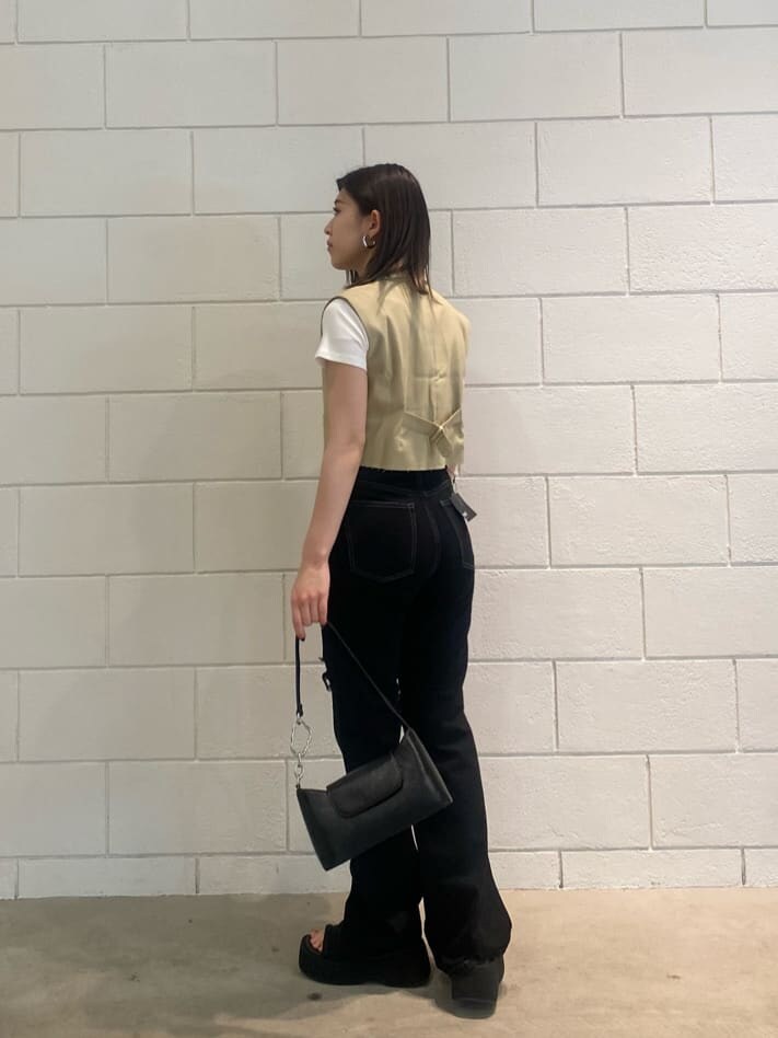 ブラック系のハンドバッグ、ホワイト系のTシャツ/カットソー、イエロー系のテーラードジャケットを着用したレディースの夏コーディネートの3枚目の写真