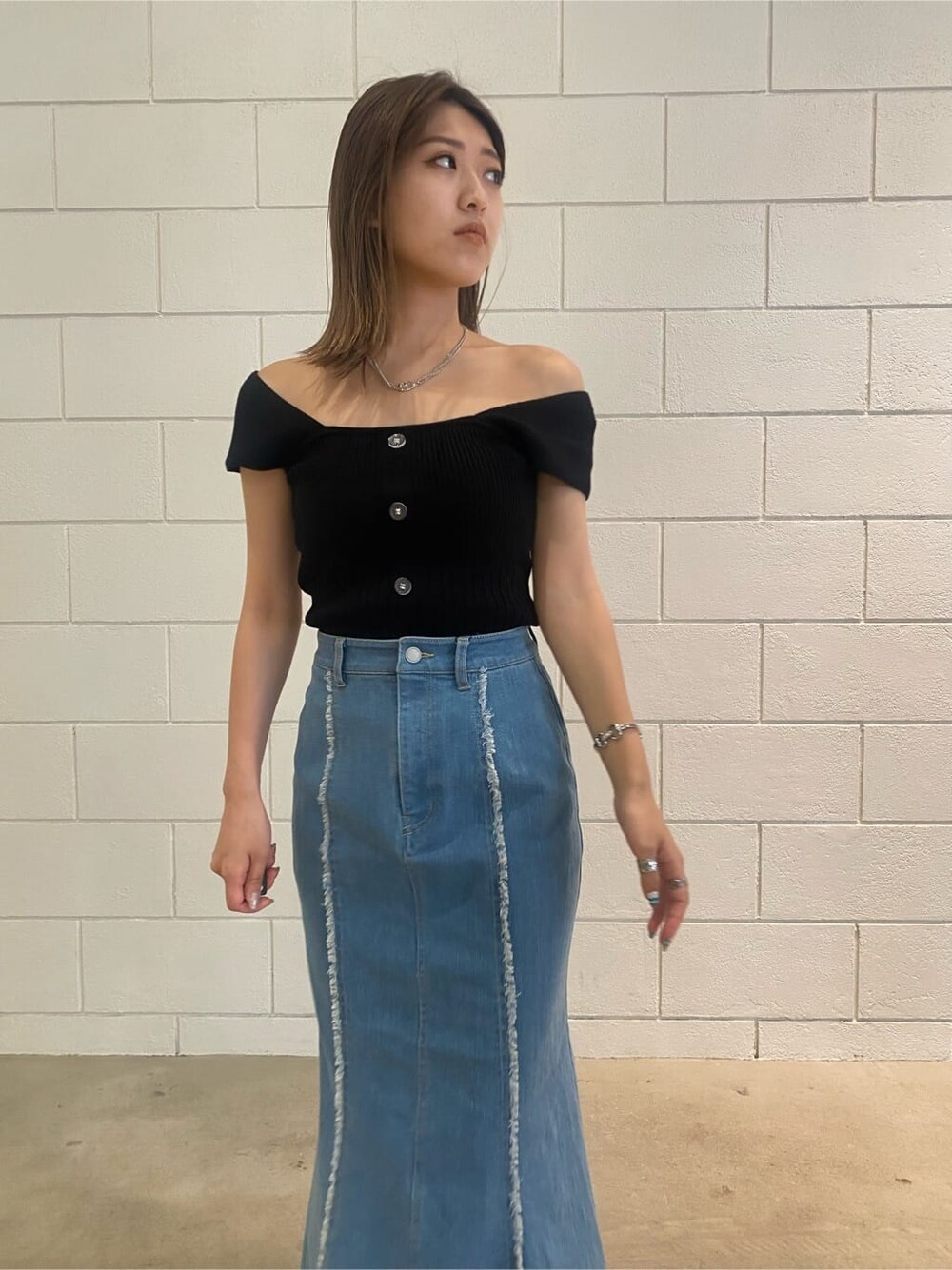 ブラウン系のハンドバッグ、ブルー系のスカート、ブラック系のタンクトップを着用したレディースの夏コーディネートの5枚目の写真