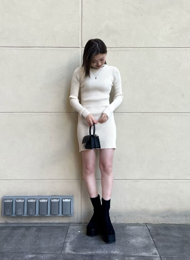 ブラック系のブーツ、ベージュ系のその他アウター、ホワイト系のワンピースを着用したレディースの冬コーディネートの4枚目の写真