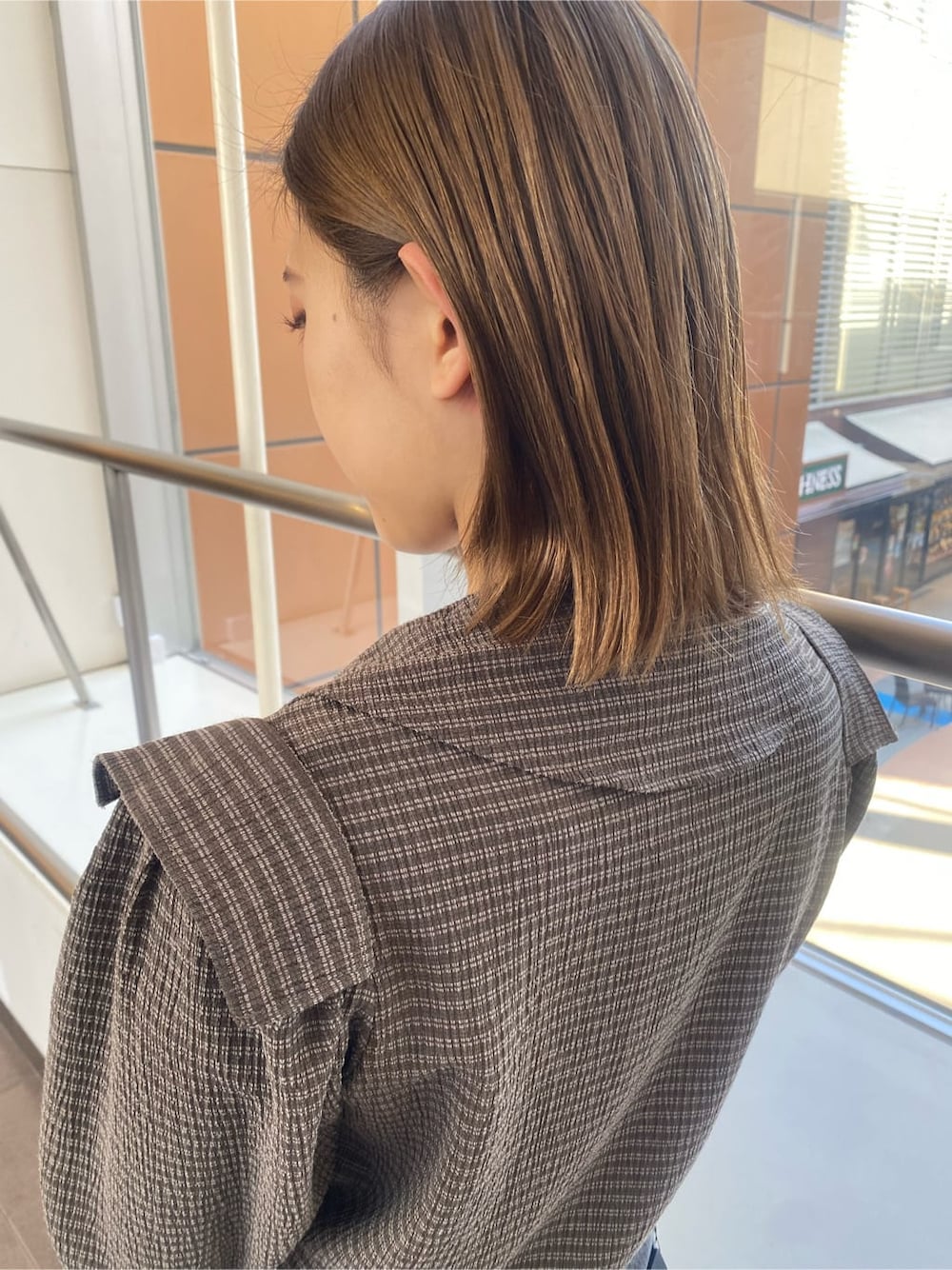 ホワイト系のローファー、グレー系のデニムパンツ、ブラウン系のシャツ/ブラウスを着用したレディースの冬コーディネートの4枚目の写真