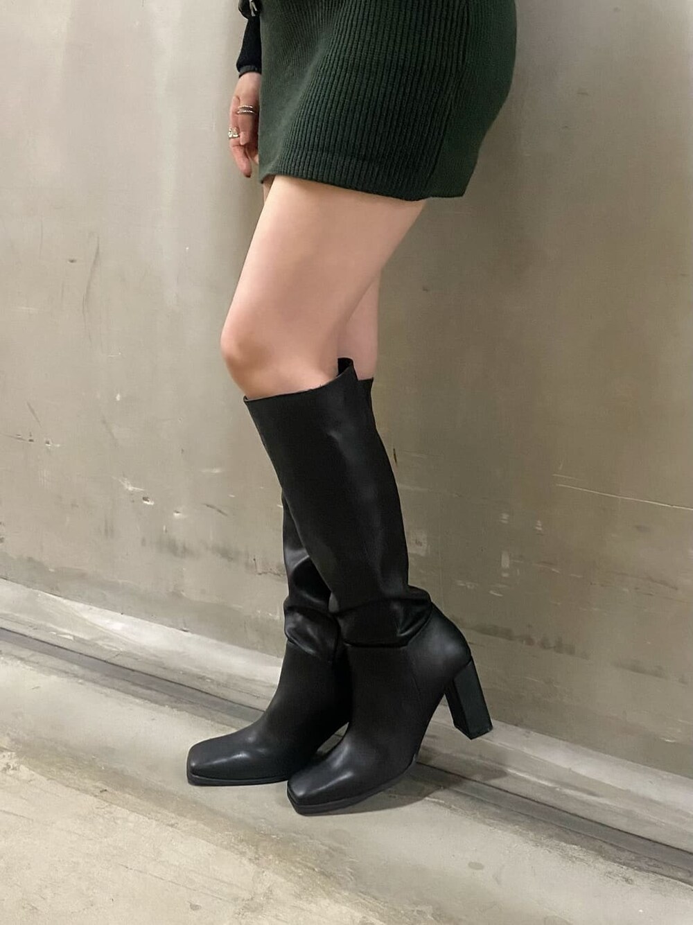 ブラック系のブルゾン、グリーン系のワンピース、ブラック系のブーツを着用したレディースの秋コーディネートの5枚目の写真