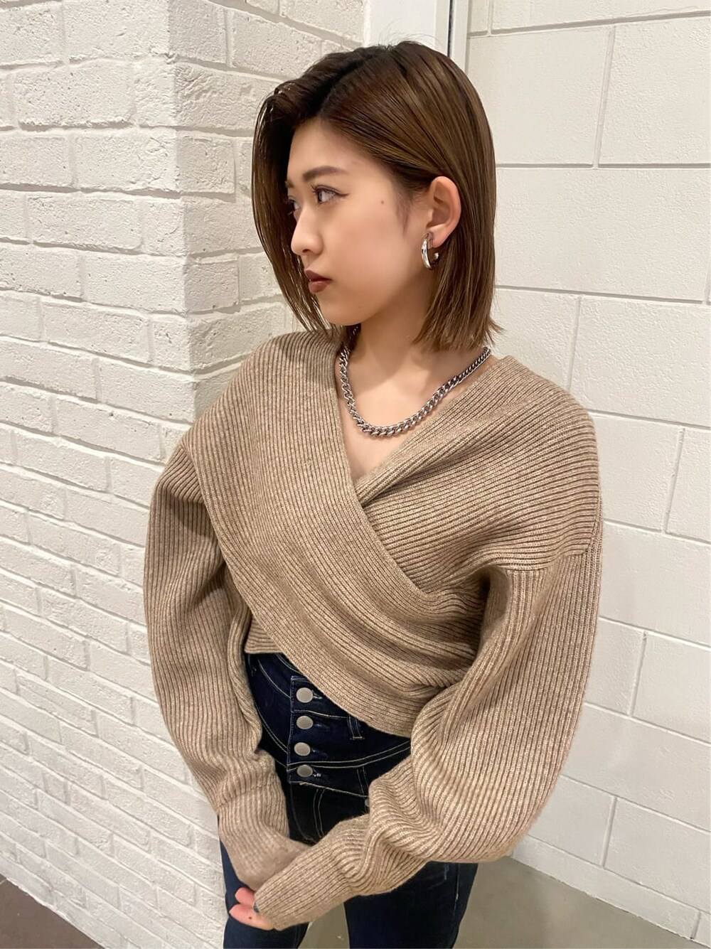 ブルー系のデニムパンツ、ブラック系のローファー、ベージュ系のニット/セーターを着用したレディースの冬コーディネートの4枚目の写真