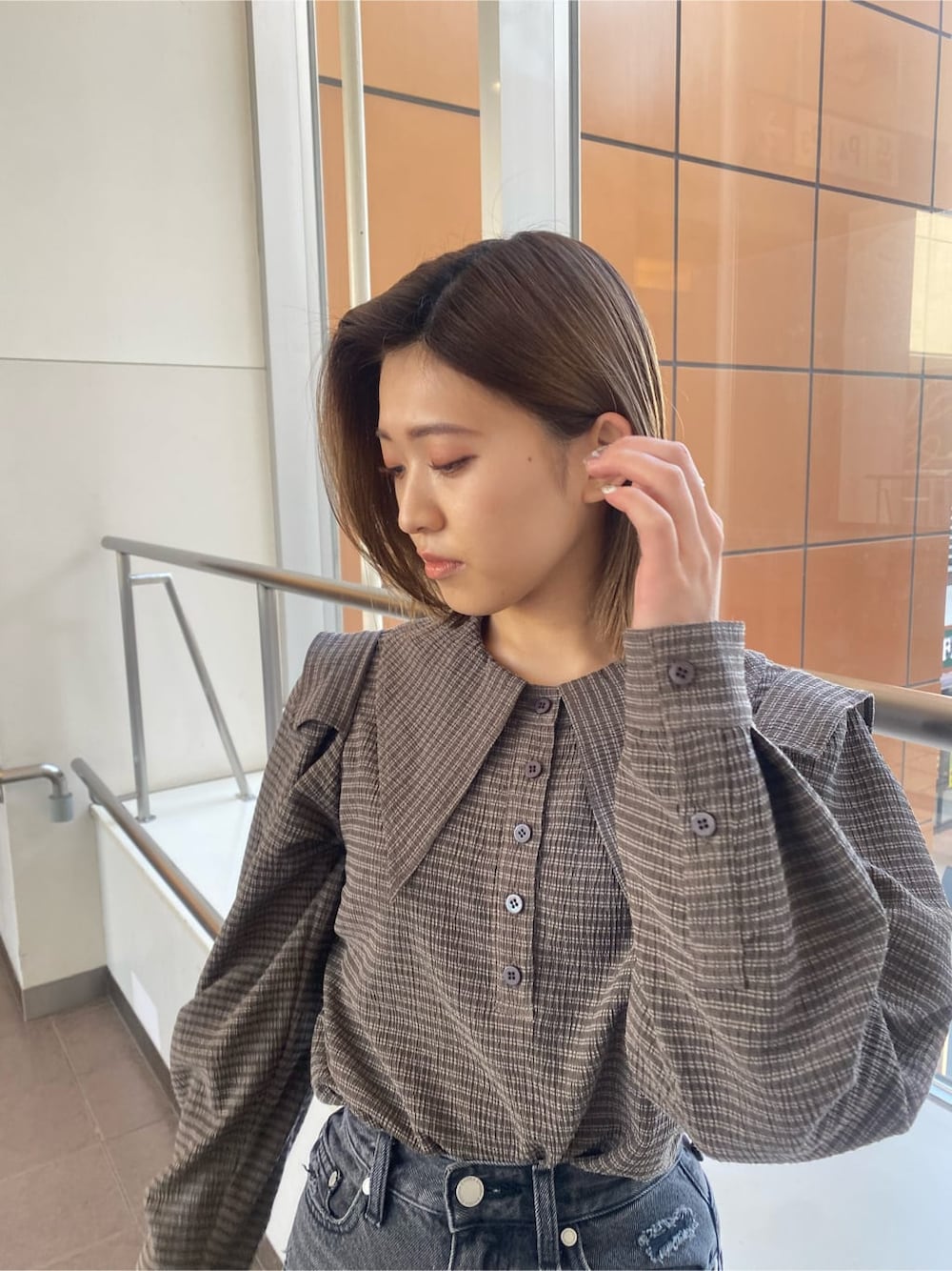 ホワイト系のローファー、グレー系のデニムパンツ、ブラウン系のシャツ/ブラウスを着用したレディースの冬コーディネートの5枚目の写真