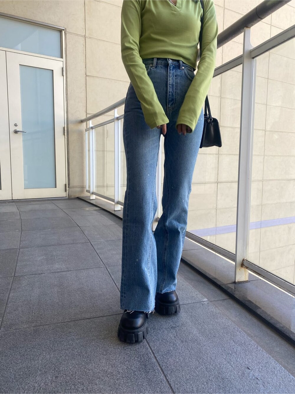 ブラック系のブーツ、ブルー系のデニムパンツ、イエロー系のTシャツ/カットソーを着用したレディースの冬コーディネートの8枚目の写真