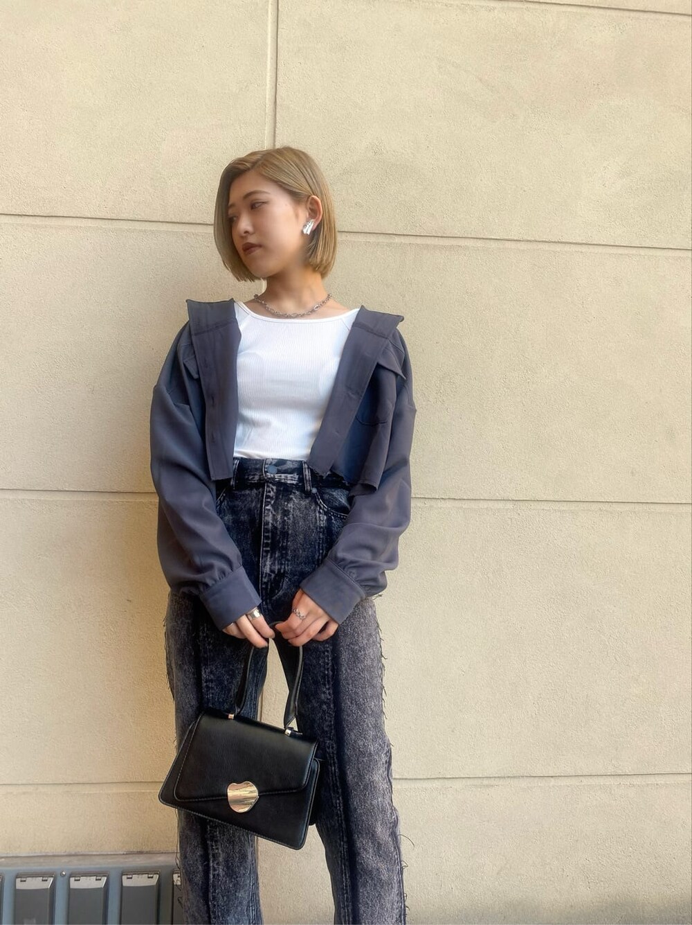 ブルー系のテーラードジャケット、ブラック系のハンドバッグ、ホワイト系のTシャツ/カットソーを着用したレディースの夏コーディネートの4枚目の写真