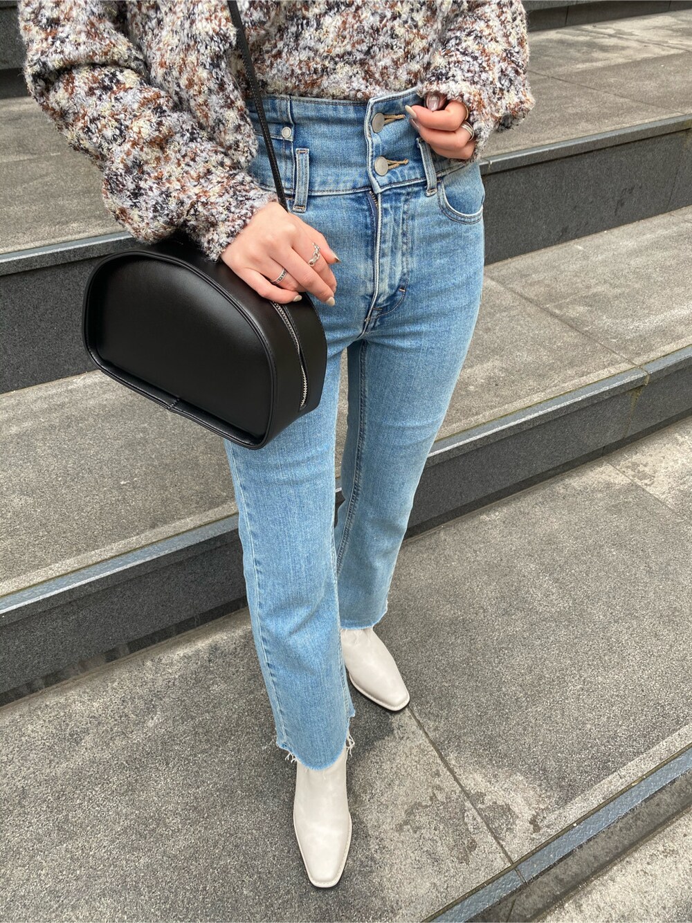 ブルー系のデニムパンツ、ホワイト系のブーツ、ホワイト系のニット/セーターを着用したレディースの冬コーディネートの3枚目の写真