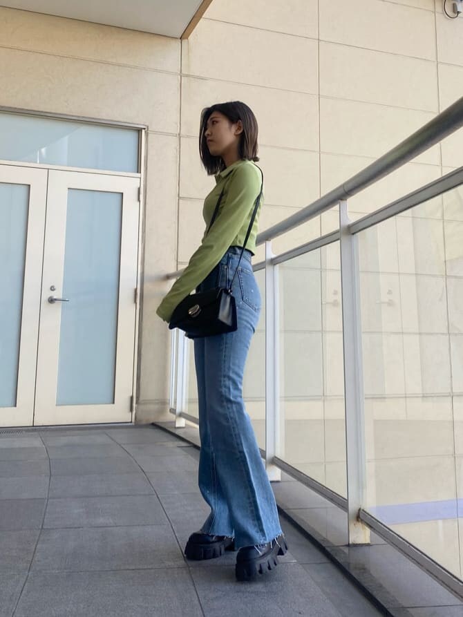 ブラック系のブーツ、ブルー系のデニムパンツ、イエロー系のTシャツ/カットソーを着用したレディースの冬コーディネートの2枚目の写真