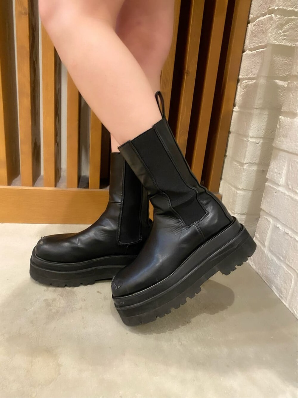 ブラック系のスカート、ホワイト系のダウンジャケット/コート、グリーン系のニット/セーターを着用したレディースの冬コーディネートの8枚目の写真