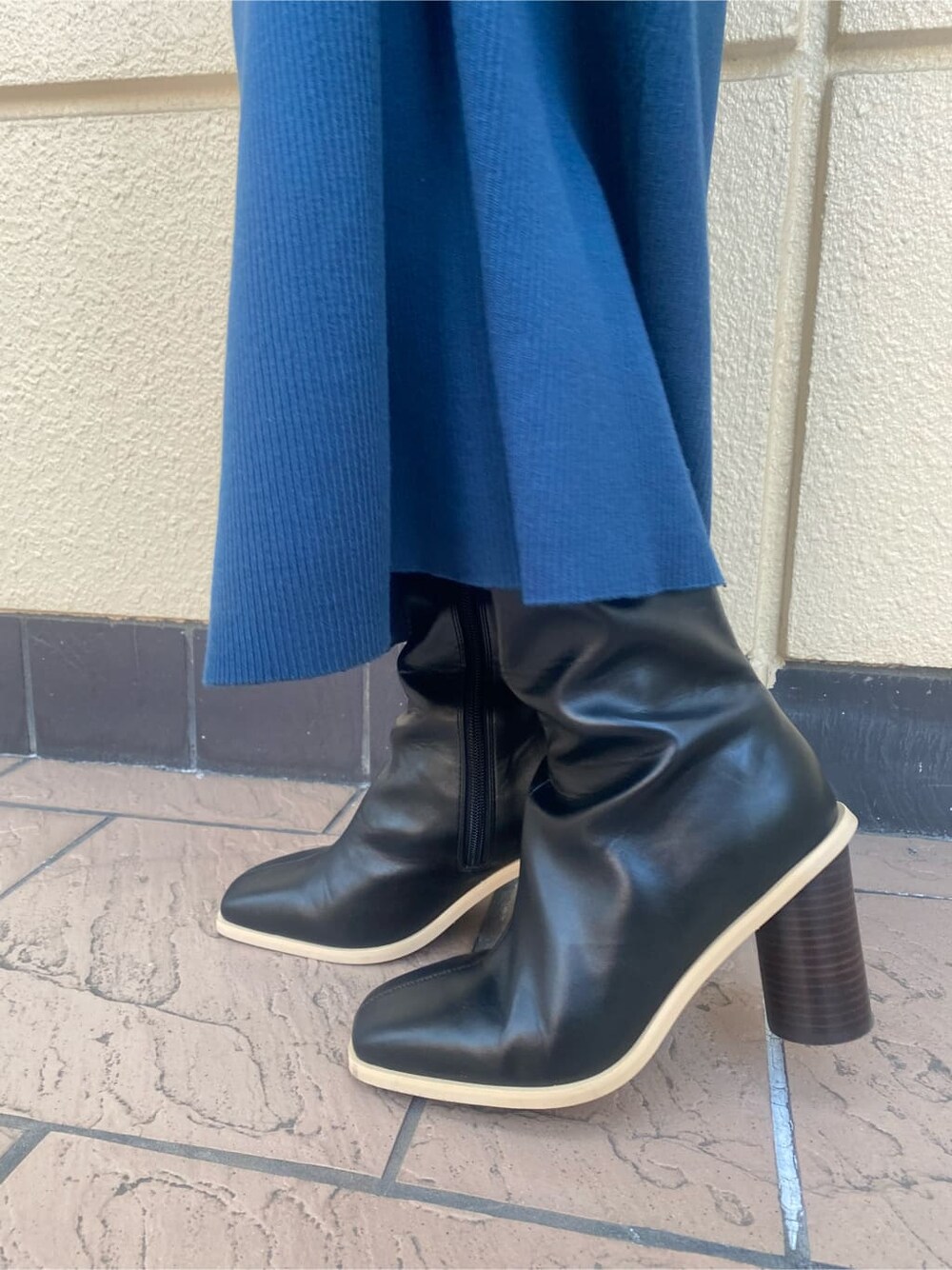 ブルー系のワンピース、ベージュ系のトレンチコート、ブラック系のブーツを着用したレディースの冬コーディネートの6枚目の写真