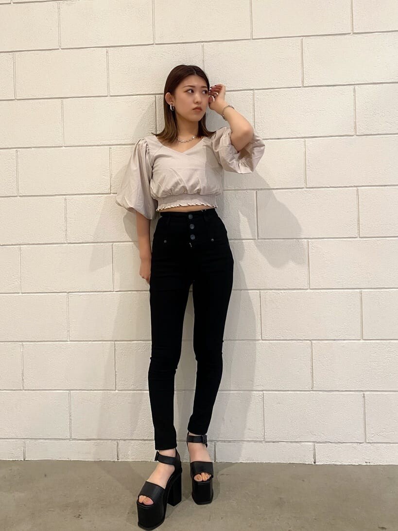 ブラック系のデニムパンツ、ブラック系のサンダル、ホワイト系のTシャツ/カットソーを着用したレディースの夏コーディネートの2枚目の写真