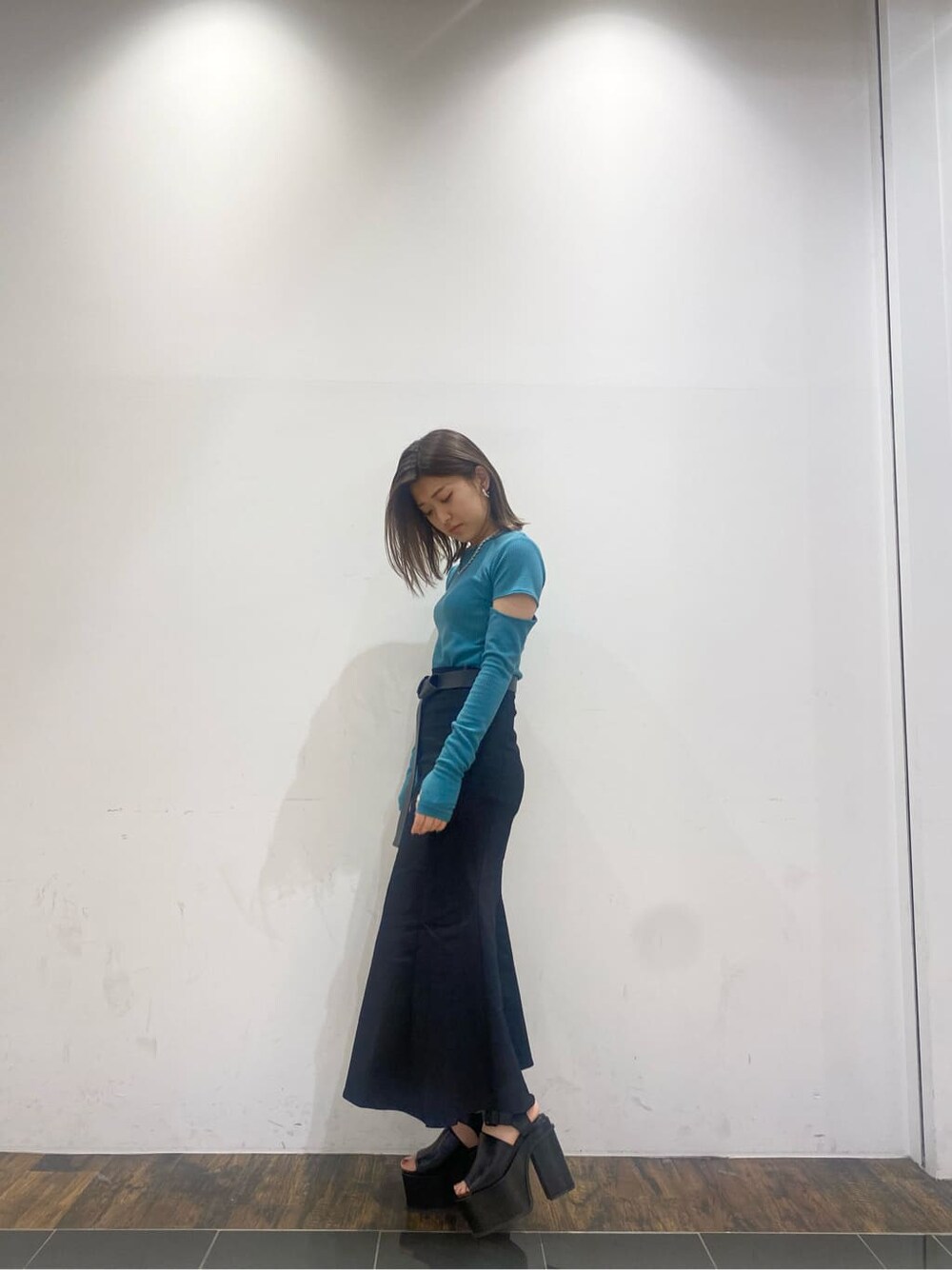 ブラック系のスカート、ブラック系のサンダル、ブルー系のTシャツ/カットソーを着用したレディースの春コーディネートの2枚目の写真