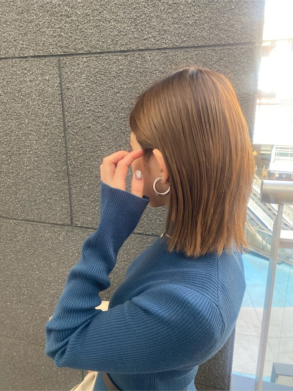 ブルー系のワンピース、ベージュ系のトレンチコート、ブラック系のブーツを着用したレディースの冬コーディネートの10枚目の写真