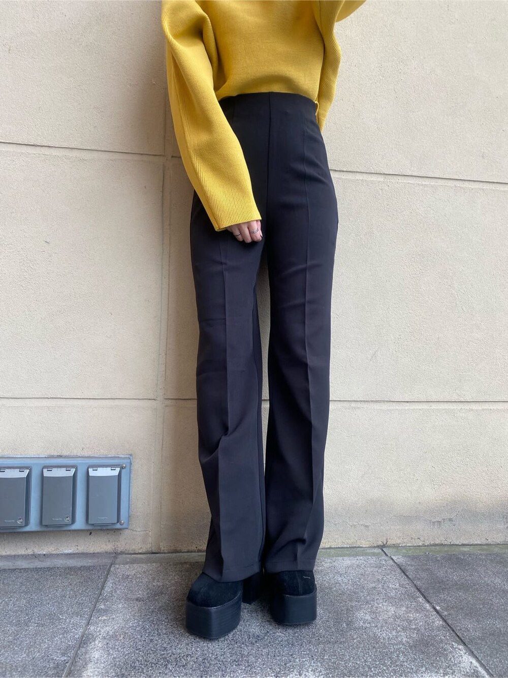 ブラック系のブーツ、ブラック系のその他パンツ、イエロー系のニット/セーターを着用したレディースの秋コーディネートの7枚目の写真