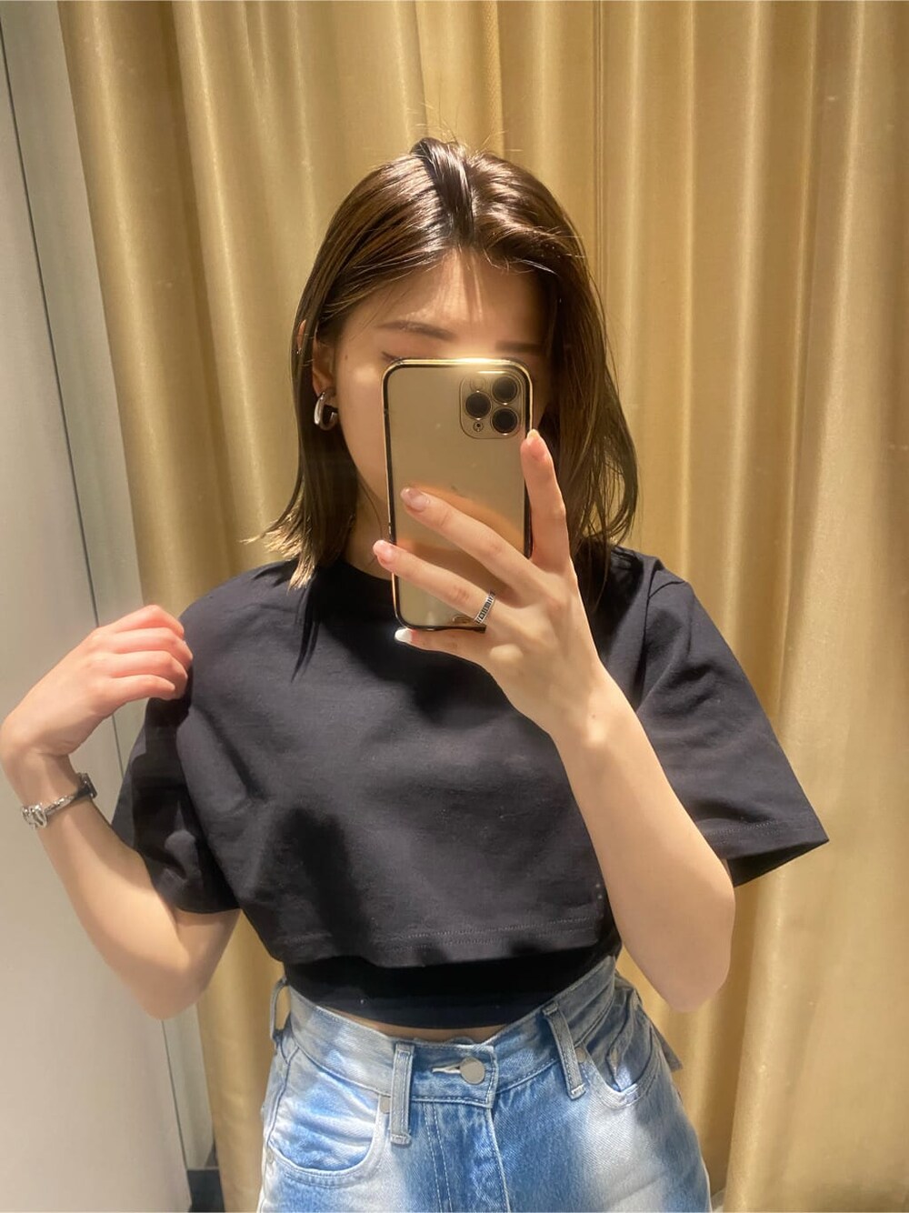 ブラック系のサンダル、ブラック系のTシャツ/カットソー、ブルー系のデニムパンツを着用したレディースの春コーディネートの5枚目の写真