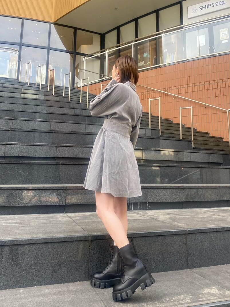 グレー系のシャツワンピース、ブラック系のブーツを着用したレディースの冬コーディネートの2枚目の写真