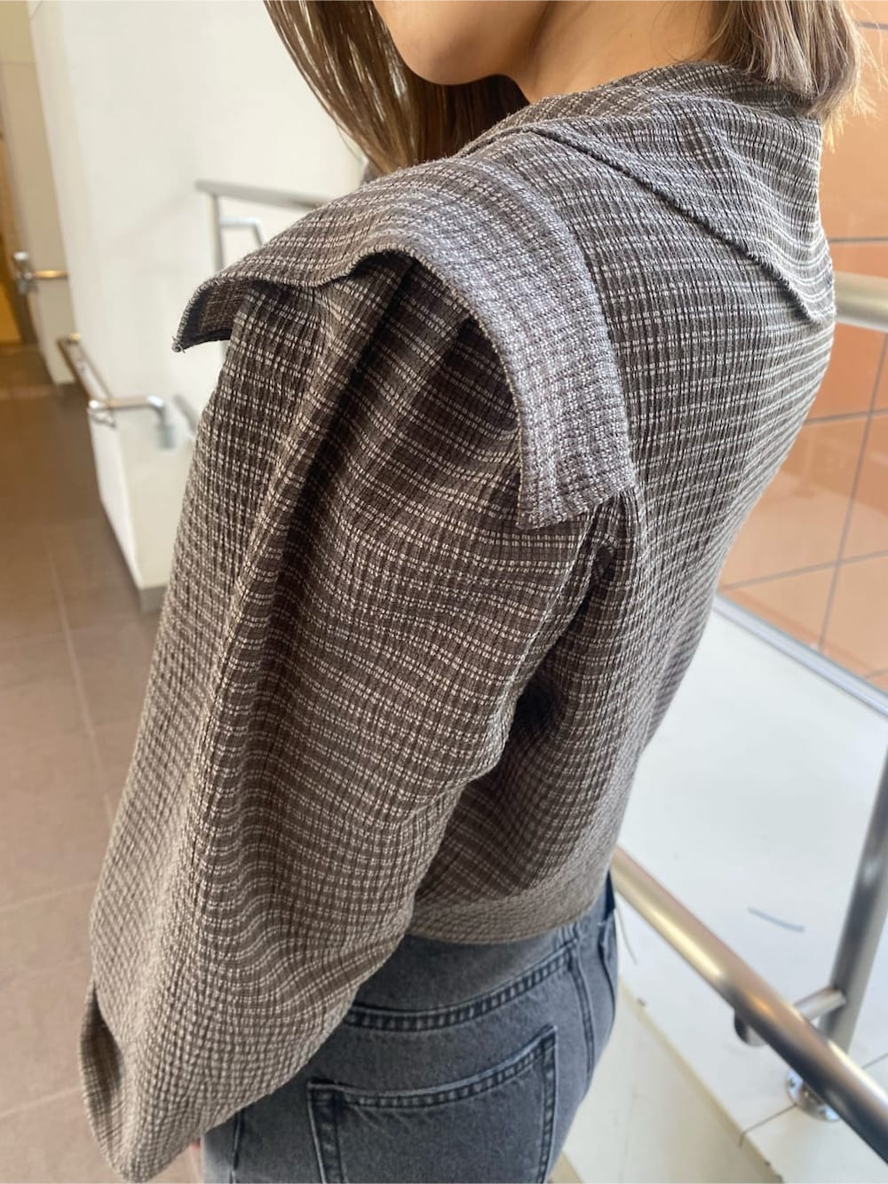 ホワイト系のローファー、グレー系のデニムパンツ、ブラウン系のシャツ/ブラウスを着用したレディースの冬コーディネートの3枚目の写真