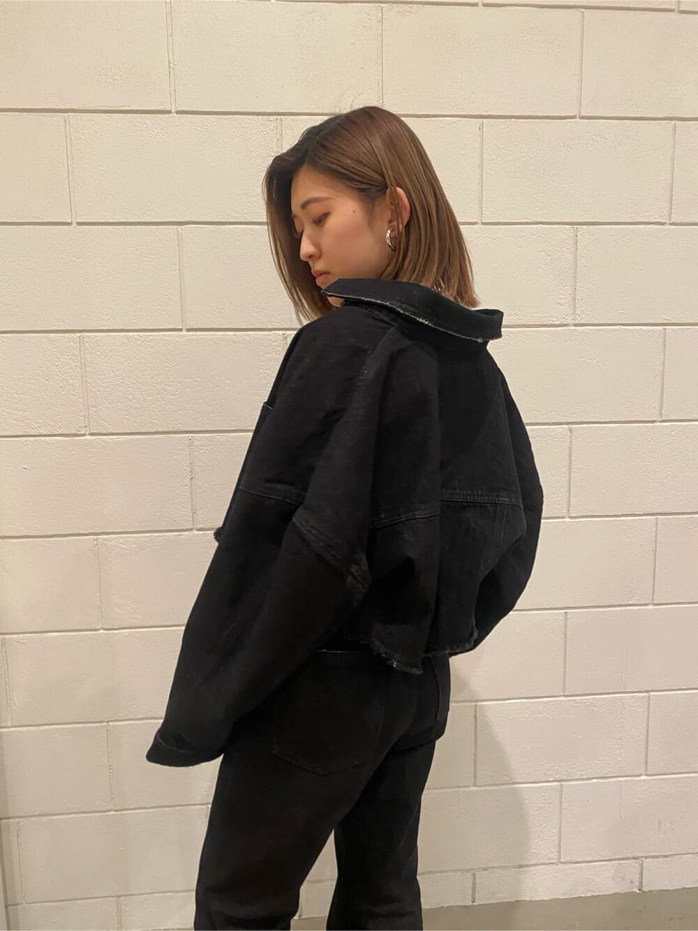 ホワイト系のローファー、グレー系のキャミソール、ブラック系のデニムジャケットを着用したレディースの春コーディネートの8枚目の写真