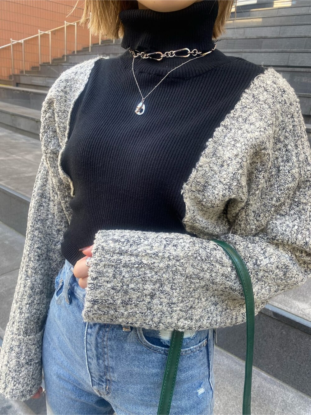 ブルー系のデニムパンツ、ブラック系のニット/セーター、ブラック系のチェスターコートを着用したレディースの秋コーディネートの7枚目の写真