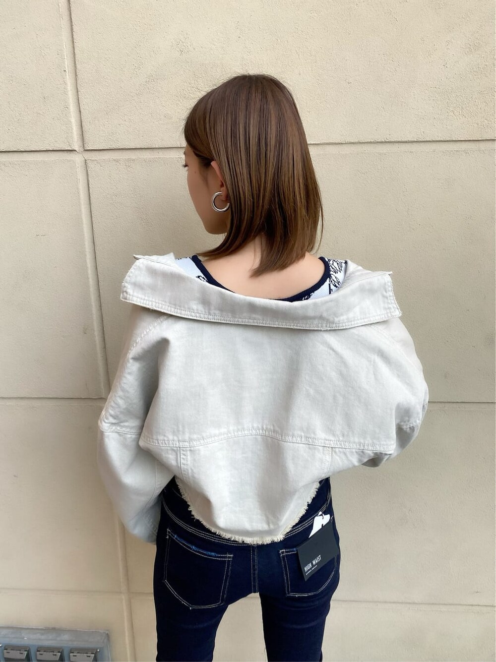 ブルー系のデニムパンツ、ホワイト系のデニムジャケット、ブラック系のサンダルを着用したレディースの春コーディネートの8枚目の写真