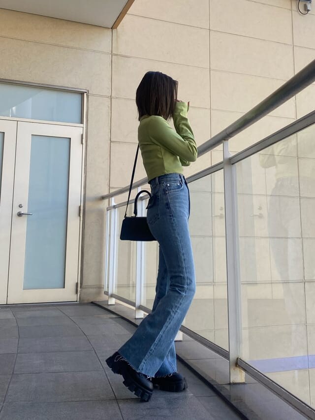 ブラック系のブーツ、ブルー系のデニムパンツ、イエロー系のTシャツ/カットソーを着用したレディースの冬コーディネートの3枚目の写真