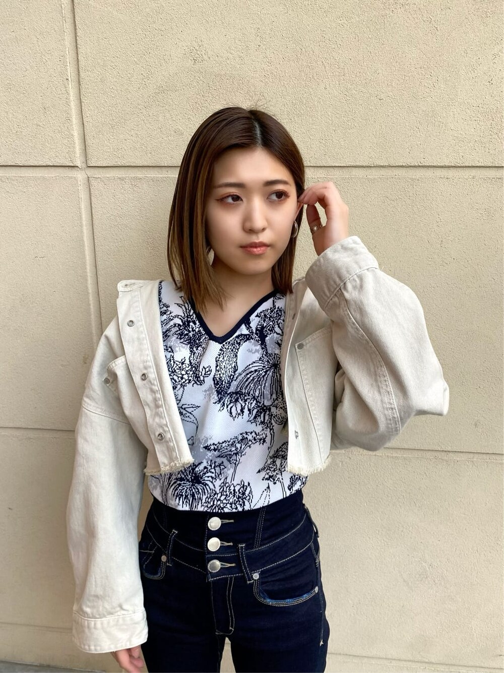 ブルー系のデニムパンツ、ホワイト系のデニムジャケット、ブラック系のサンダルを着用したレディースの春コーディネートの6枚目の写真