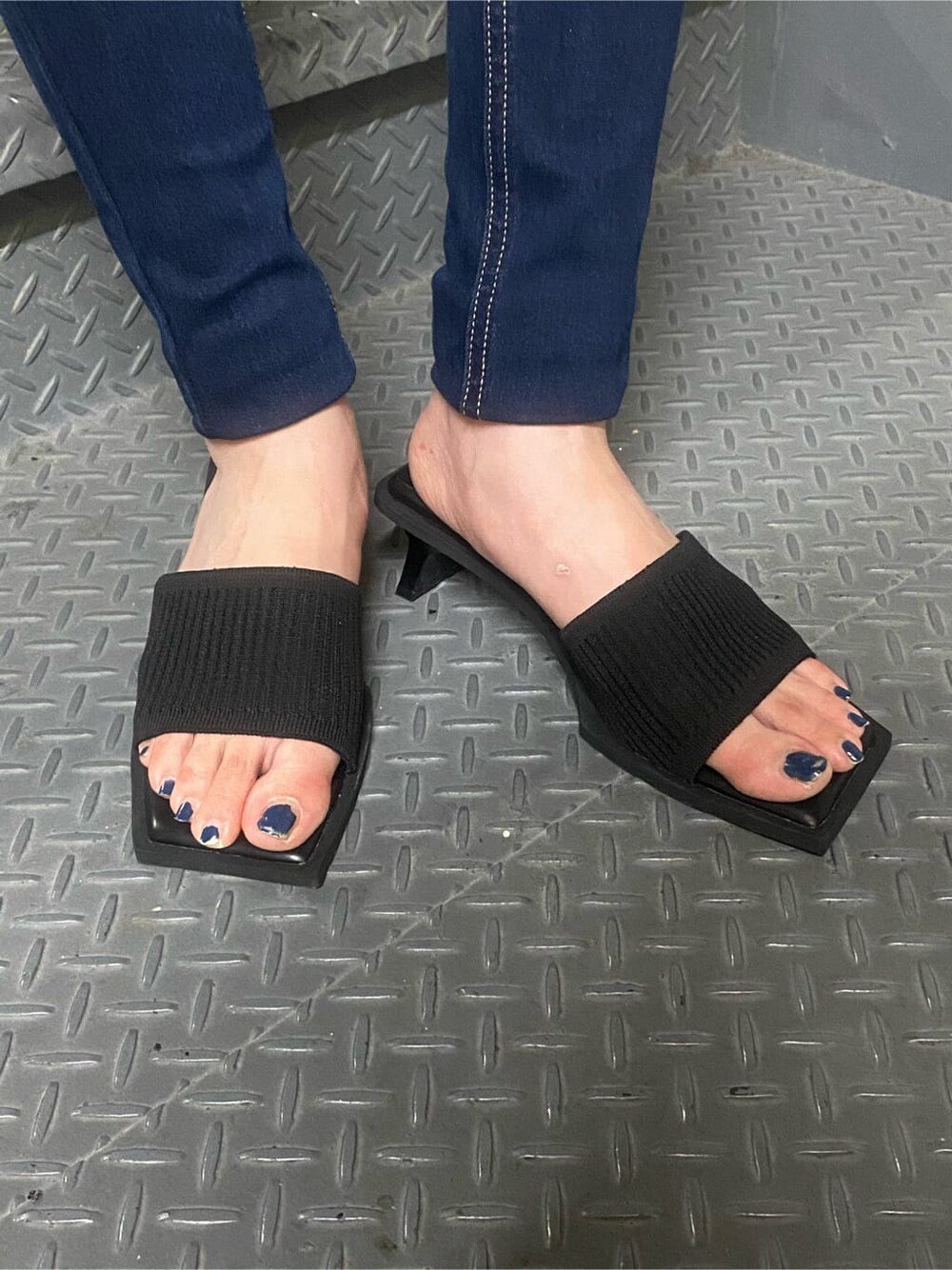 ブラック系のサンダル、ブルー系のデニムパンツを着用したレディースの夏コーディネートの6枚目の写真