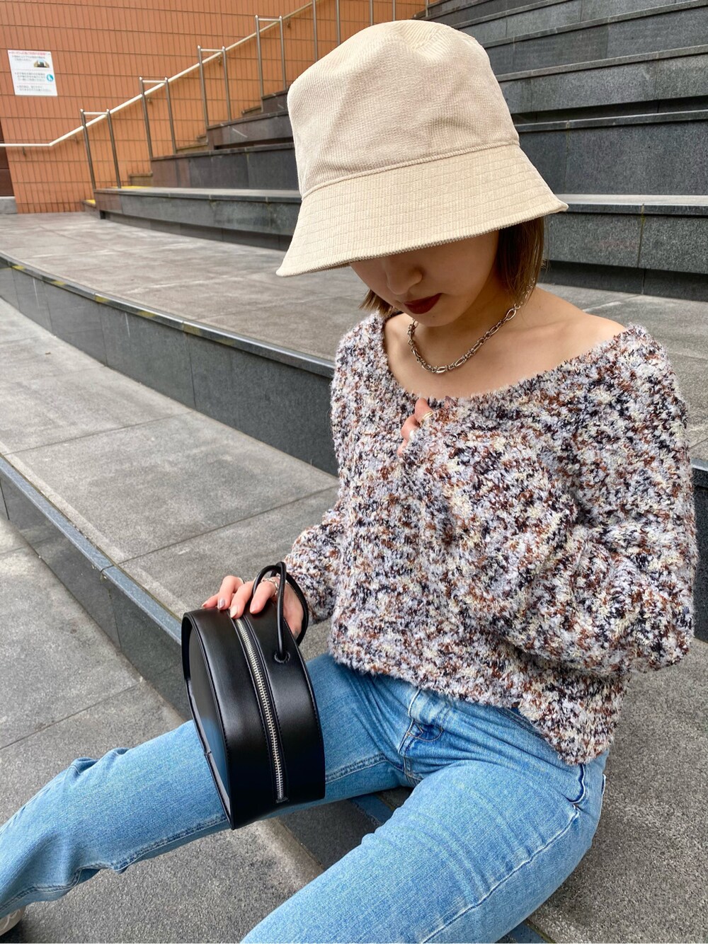 ブルー系のデニムパンツ、ホワイト系のブーツ、ホワイト系のニット/セーターを着用したレディースの冬コーディネートの2枚目の写真