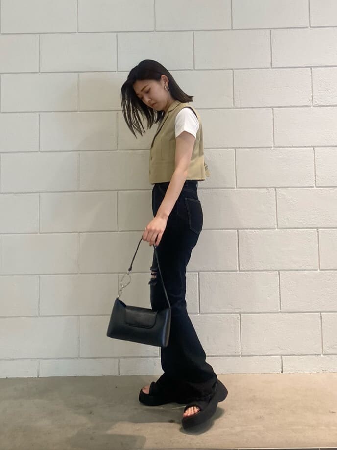 ブラック系のハンドバッグ、ホワイト系のTシャツ/カットソー、イエロー系のテーラードジャケットを着用したレディースの夏コーディネートの2枚目の写真