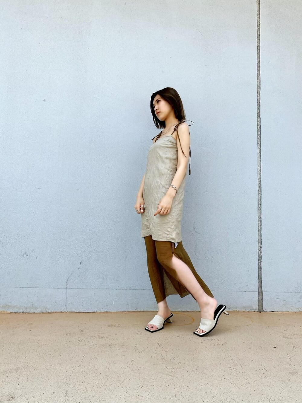 ベージュ系のワンピース、ホワイト系のサンダルを着用したレディースの夏コーディネートの2枚目の写真