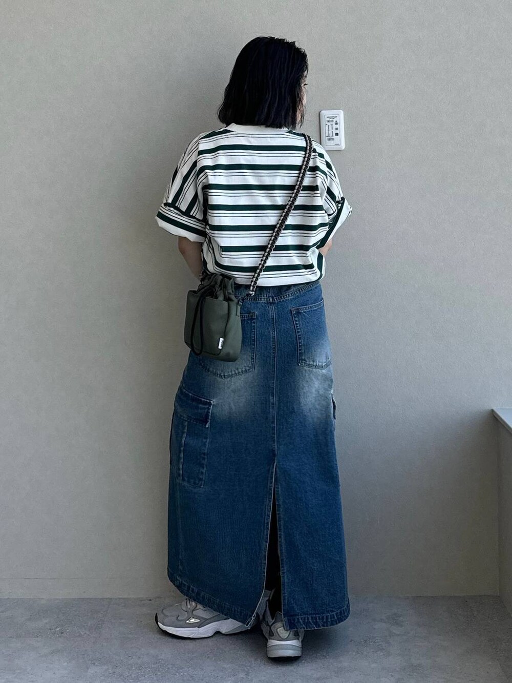 ブルー系のデニムスカート、グリーン系のショルダーバッグ、その他のTシャツ/カットソーを着用したレディースの春コーディネートの4枚目の写真