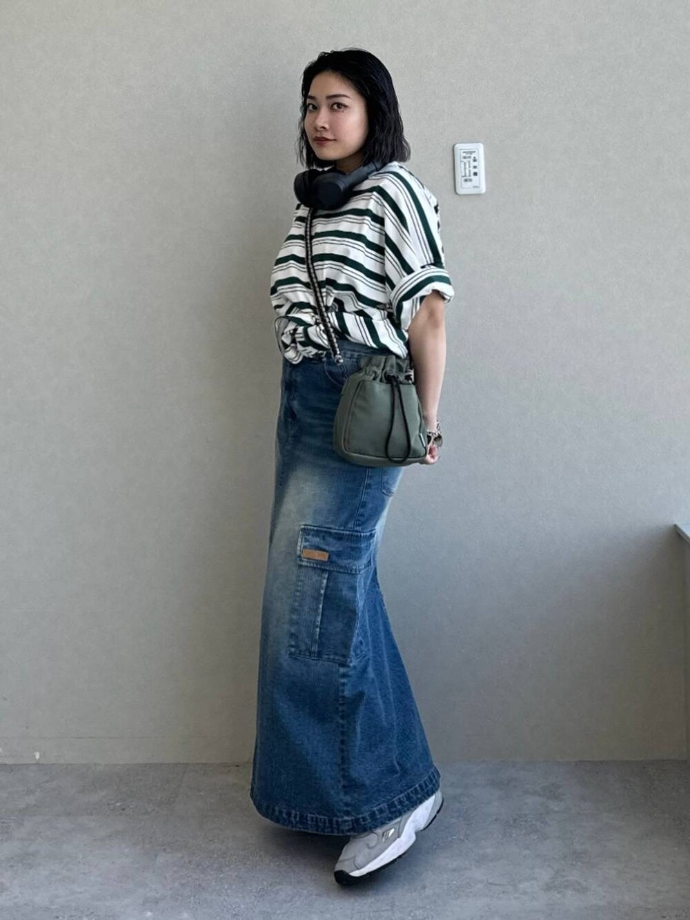 ブルー系のデニムスカート、グリーン系のショルダーバッグ、その他のTシャツ/カットソーを着用したレディースの春コーディネートの2枚目の写真