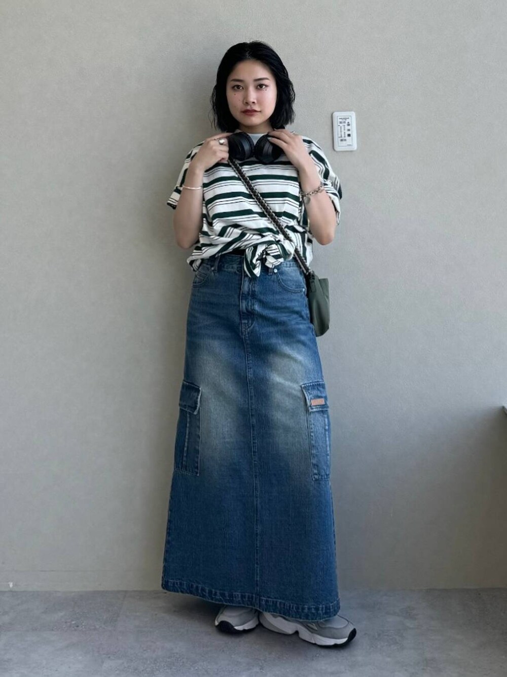 ブルー系のデニムスカート、グリーン系のショルダーバッグ、その他のTシャツ/カットソーを着用したレディースの春コーディネートの3枚目の写真