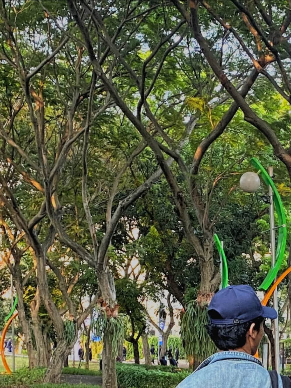 ホワイト系のスニーカー、ブラック系のスラックス、ブルー系のデニムジャケットを着用したメンズの夏コーディネートの4枚目の写真