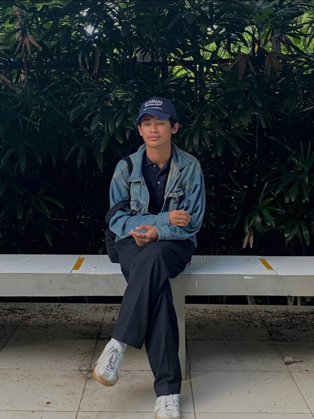 ホワイト系のスニーカー、ブラック系のスラックス、ブルー系のデニムジャケットを着用したメンズの夏コーディネートの3枚目の写真